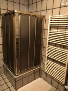 a shower stall in a tiled bathroom at Pension Fischer in Bad Driburg