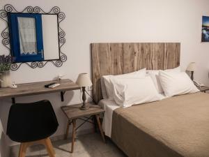 a bedroom with a bed and a desk with a mirror at Fragoulis Village in Parasporos