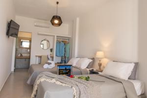 a bedroom with two beds and a tv in it at Fragoulis Village in Parasporos