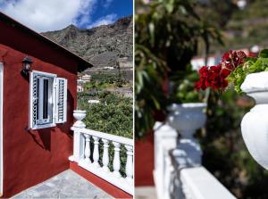 a red building with a white fence and a vase with flowers at CASA CARLOS - HERMIGUA in Hermigua