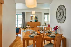 comedor y sala de estar con mesa y sillas en Casas Barulho Albufeira Marina en Albufeira