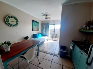 Cette chambre comprend un lit, une table et une horloge. dans l'établissement Croeso Guest House, à Langebaan