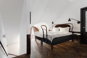 Miss Clara by Nobis, Stockholm, a Member of Design Hotels™ في ستوكهولم: غرفة نوم مع سرير مع اللوح الأمامي الأسود والأبيض
