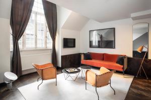 ein Wohnzimmer mit einem roten Sofa und Stühlen in der Unterkunft Miss Clara by Nobis, Stockholm, a Member of Design Hotels™ in Stockholm