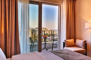 a bedroom with a bed and a balcony with a view at Hotel Bono in Budva