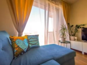 a living room with a blue couch and a window at Bučiukas in Palanga