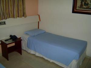 a bedroom with a bed and a table with a phone at Hotel Urubupunga in Ilha Solteira +27 photos