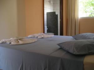 a bed with two towels on top of it at Hotel Urubupunga in Ilha Solteira