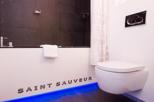 
a white toilet sitting next to a white wall at Hotel Saint Sauveur by WP Hotels in Blankenberge
