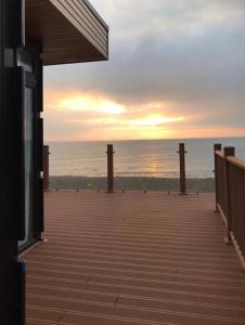 a deck with a view of the ocean at sunset at Loughanmore Court Beach house in Dundalk +16 photos