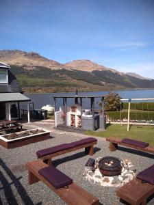 einen Picknickbereich mit Bänken und einem Kamin in der Unterkunft THE ANCHORAGE in Arrochar