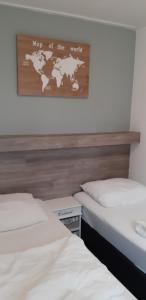 2 Betten in einem Zimmer mit einer Weltkarte in der Unterkunft Bij De Vuurtoren in Hollum