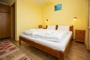 a bedroom with a bed with white sheets and pillows at Júlia Panzió in Hajdúszoboszló