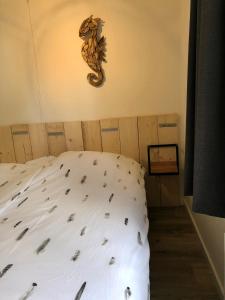 een slaapkamer met een bed met een zeepaardje aan de muur bij Puur Texels 6 in De Koog