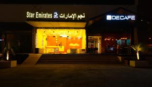 una tienda por la noche con un cartel. en Star Emirates Downtown, en Salalah