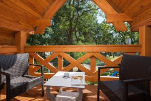 une terrasse en bois avec 2 chaises et une table. dans l'établissement Domki Hallerowka Resort, à Władysławowo