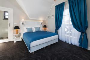 Dormitorio azul y blanco con cama y ventana en Domki Hallerowka Resort en Władysławowo