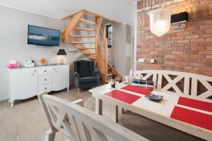 - un salon avec une table à manger et un mur en briques dans l'établissement Domki Hallerowka Resort, à Władysławowo 65 autres photos