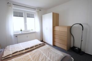 een slaapkamer met 2 bedden, een dressoir en een raam bij Appartementhaus Nige Ooge Ferienwohnung Nr. 3 in Cuxhaven