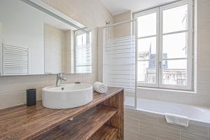 een badkamer met een wastafel, een bad en een raam bij Résidence Quélin Honfleur in Honfleur +56 foto's