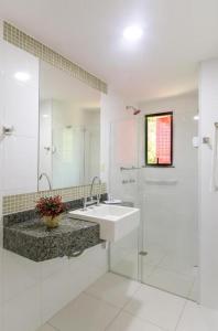a white bathroom with a sink and a shower at Seleto Hotel in Volta Redonda