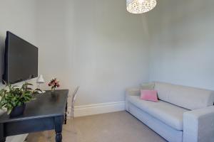 a living room with a couch and a desk with a tv at Thorndon Heritage Listed Villa in Wellington