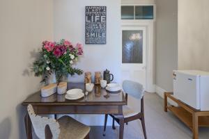 una mesa de comedor con un jarrón de flores. en Thorndon Heritage Listed Villa en Wellington