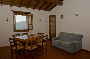 un soggiorno con un tavolo e un divano di Agriturismo Il Serrino a San Marcello Pistoiese