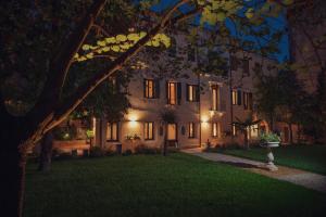 una casa grande con luces encendidas en un patio por la noche en Cinqueteste Luxury Home en Venecia