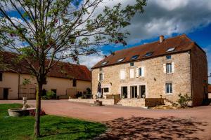 a large brick building with a tree in front of it at La Maison de Souhey in Souhey