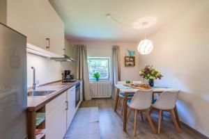 a kitchen with a table and chairs and a sink at Ferienwohnung Selina in Taching am See