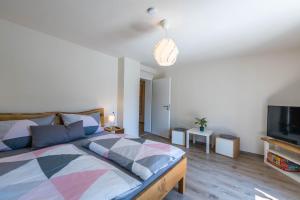 a bedroom with a bed and a flat screen tv at Ferienwohnung Selina in Taching am See