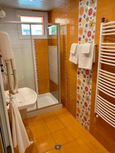 uma casa de banho com um chuveiro, um WC e um lavatório. em Hotel Elena em Veliko Tŭrnovo