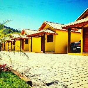 a yellow house with a driveway in front of it at Pousada Ipê da Serra in Socorro
