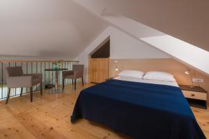 a bedroom with a blue bed and a table and chairs at Apartments Vallum in Bol