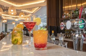 two cocktails sitting on a counter in a bar at Vert Hotel Eilat by AFI Hotels in Eilat