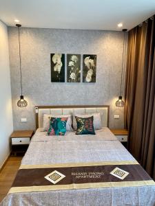 a bedroom with a bed with three pictures on the wall at Khánh Phong Homestay Greenbay Garden Hạ Long in Ha Long