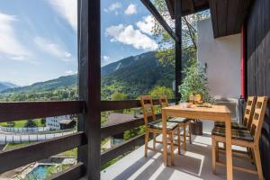 a wooden table and chairs on a balcony with a view at Chalet Ravenstein in Fiesch