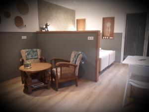 uma sala de estar com uma mesa e duas cadeiras em Bed & Breakfast Hellendoorn em Hellendoorn