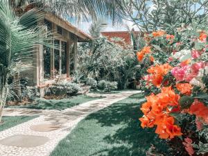 un camino frente a una casa con flores en Uluwatu Breeze Village en Uluwatu