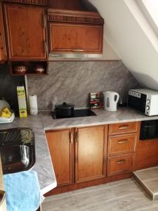 uma cozinha com armários de madeira e uma bancada em Top Center Apartment and Rooms Varna em Varna City