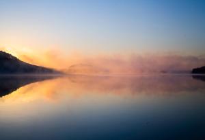 mgliste jezioro z zachodem słońca w tle w obiekcie Penzion Sklípek w mieście Staré Splavy