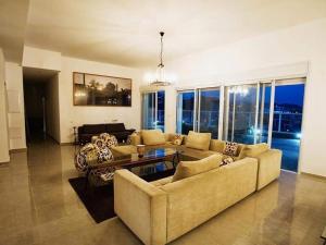 una sala de estar con un sofá y una mesa en VIP Pentathoses Eilat, en Eilat
