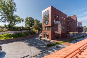 a red brick building with a roof at Merchant Signature Suites in Klaipėda