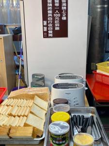 una mesa con una bandeja de pan y otros alimentos en Wankou Hotel, en Zhongzheng