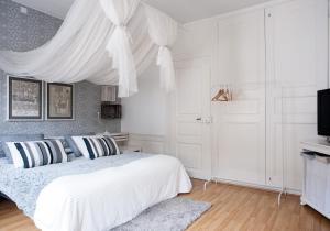 a bedroom with a bed with a white canopy at Maison DuBois in Le Locle