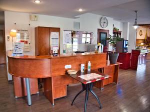 um balcão de madeira num quarto com uma mesa em Contact Hotel Le Seino Marin - Cléon Elbeuf em Cléon