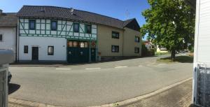 un bâtiment blanc avec une porte verte dans une rue dans l'établissement Sunshine Cottage, à Waldsolms