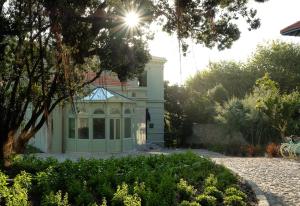 a white house with a garden in front of it at Vila Foz Hotel & SPA - member of Design Hotels in Porto