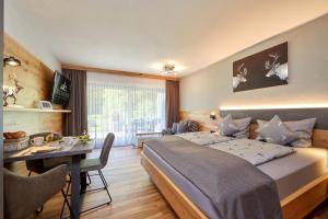 1 dormitorio con 1 cama y 1 mesa en una habitación en Gästehaus Buchenhof, en Grainau